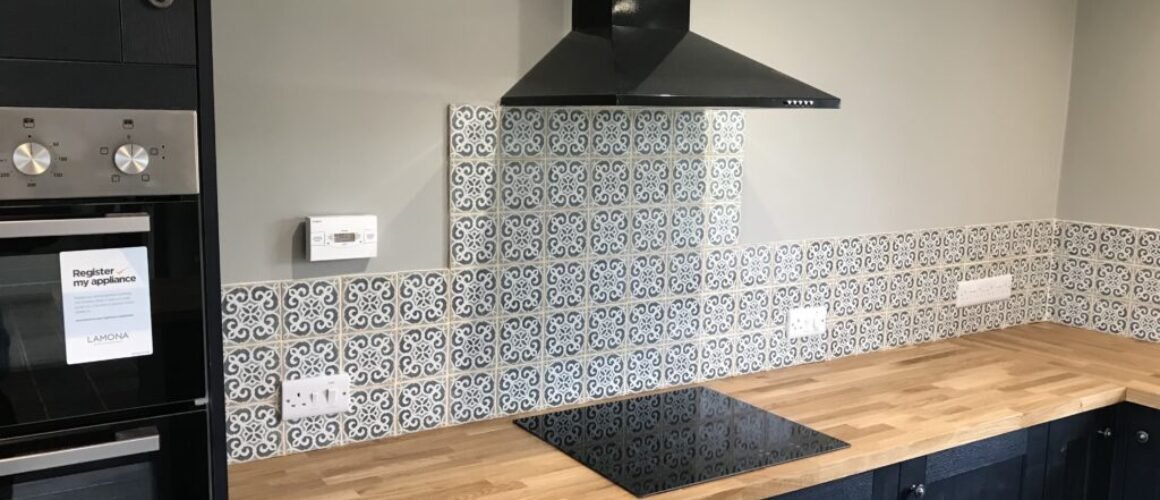 Professional tiling services in a modern kitchen with ceramic tiles on the floor and backsplash.