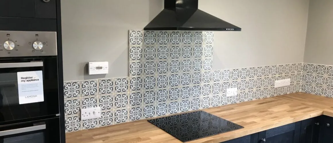 Professional tiling services in a modern kitchen with ceramic tiles on the floor and backsplash.