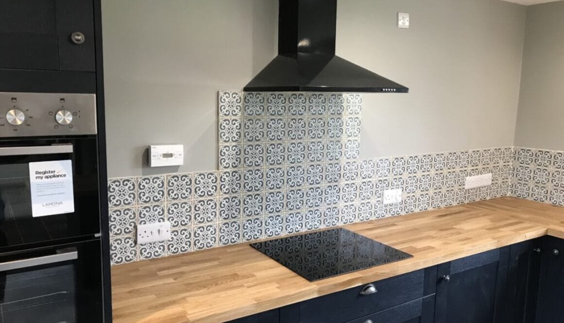 Professional tiling services in a modern kitchen with ceramic tiles on the floor and backsplash.