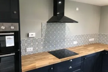 Professional tiling services in a modern kitchen with ceramic tiles on the floor and backsplash.