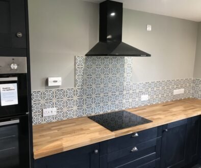 Professional tiling services in a modern kitchen with ceramic tiles on the floor and backsplash.