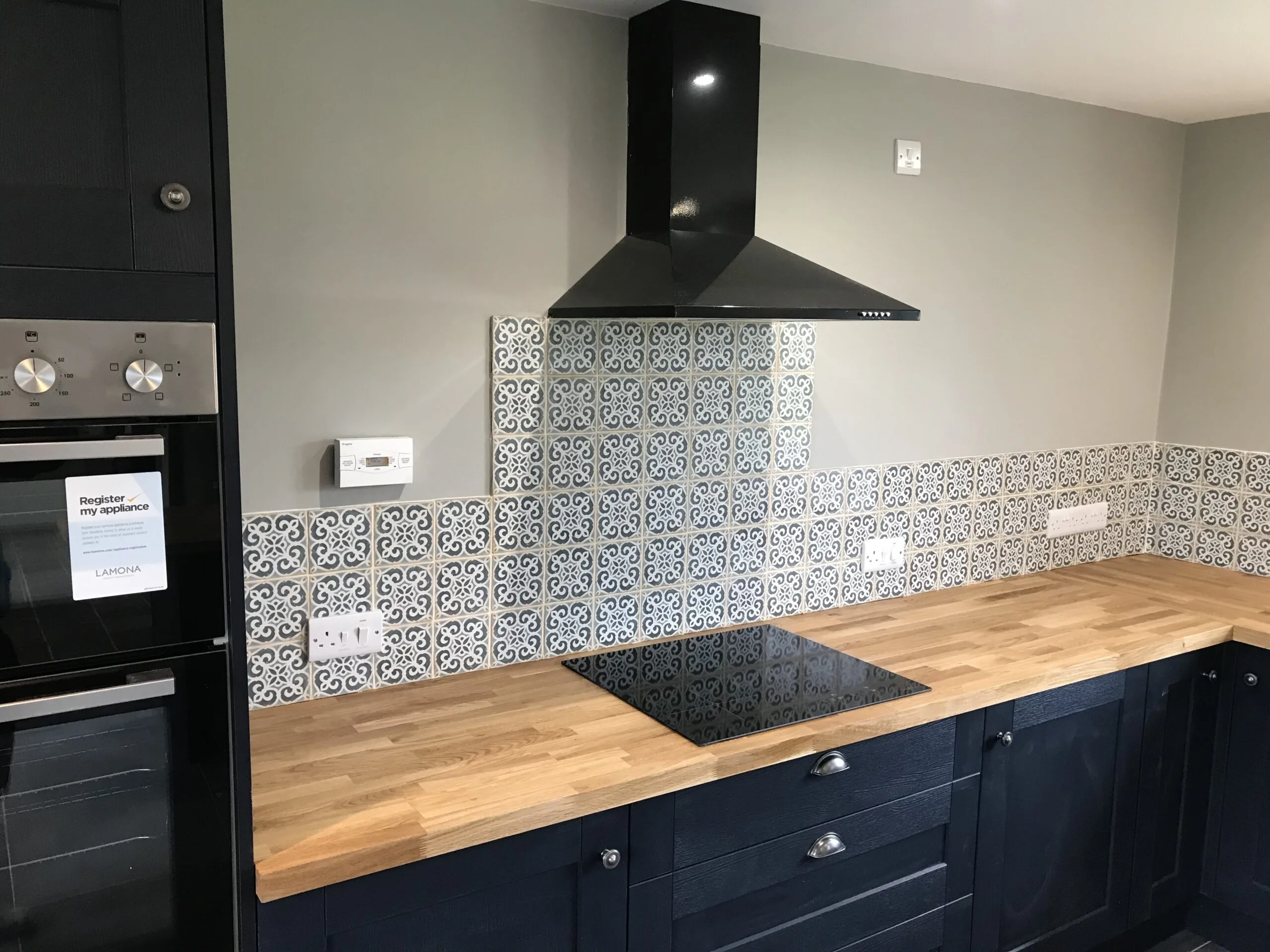 Professional tiling services in a modern kitchen with ceramic tiles on the floor and backsplash.