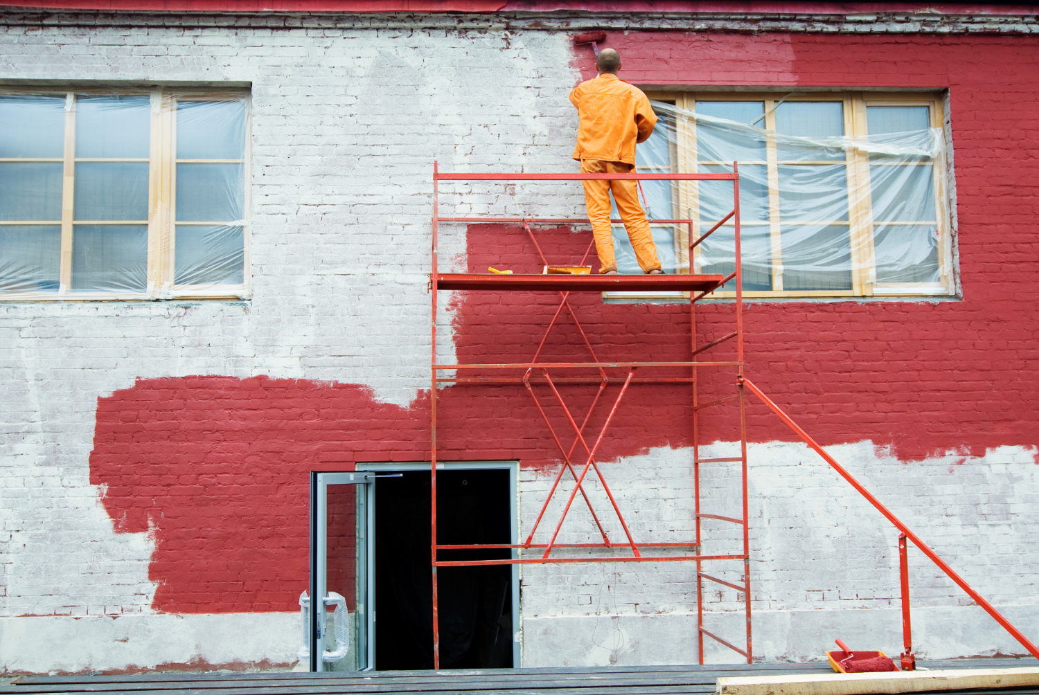 Weatherproof paint being applied to a brick wall.